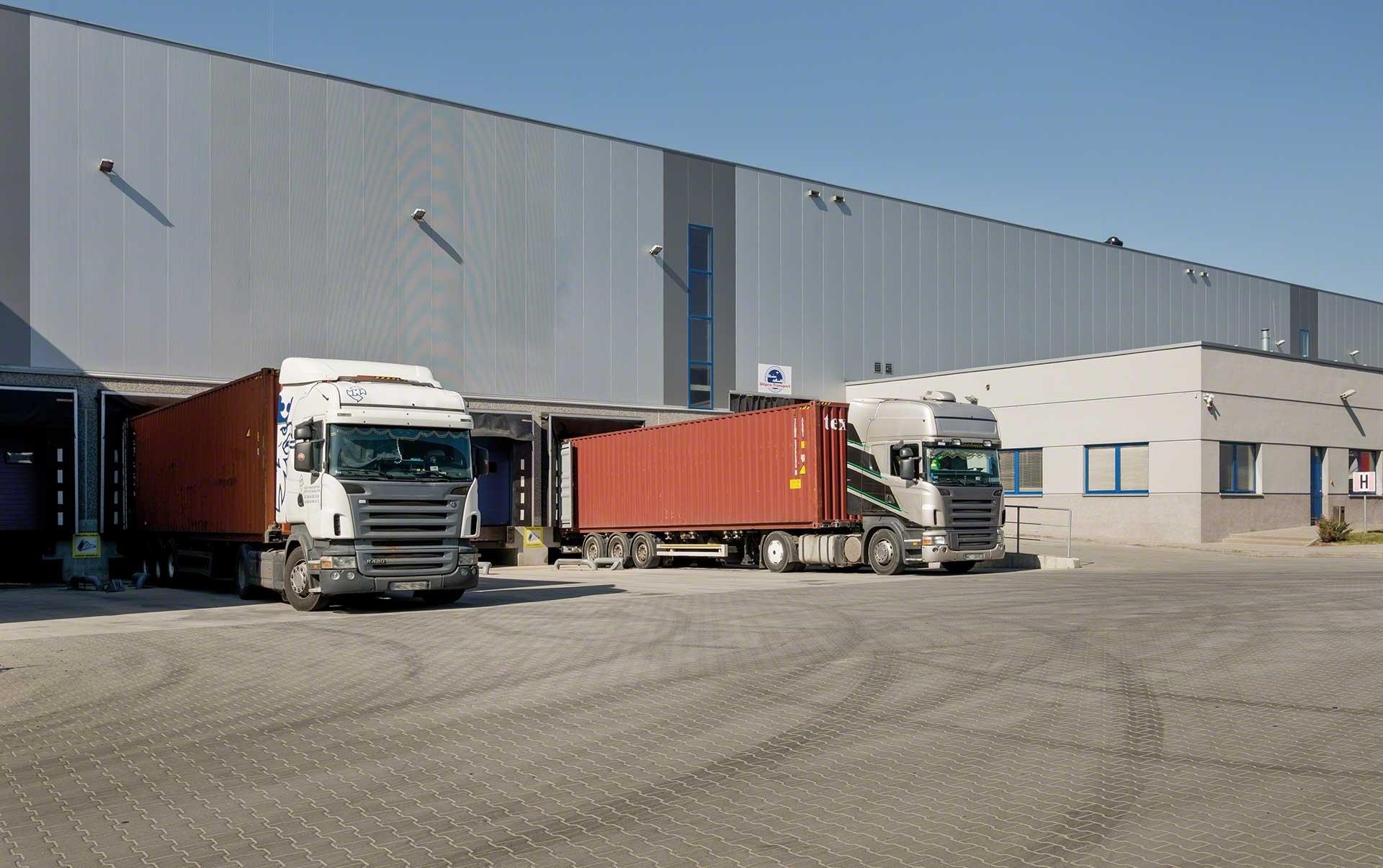Ciężarówki w dokach przeładunkowych w trakcie przyjęcia towaru do magazynu