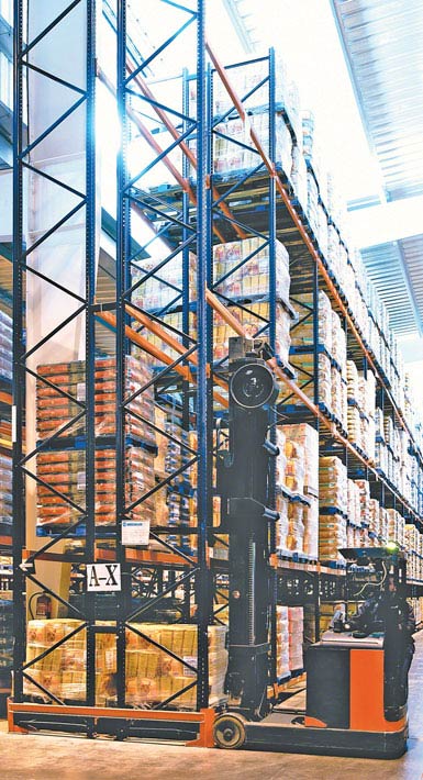 Zdjęcie wózka widłowego wysokiego składowania do regałów o podwójnej głębokości stosowanego w magazynie produktów spożywczych dużej konsumpcji