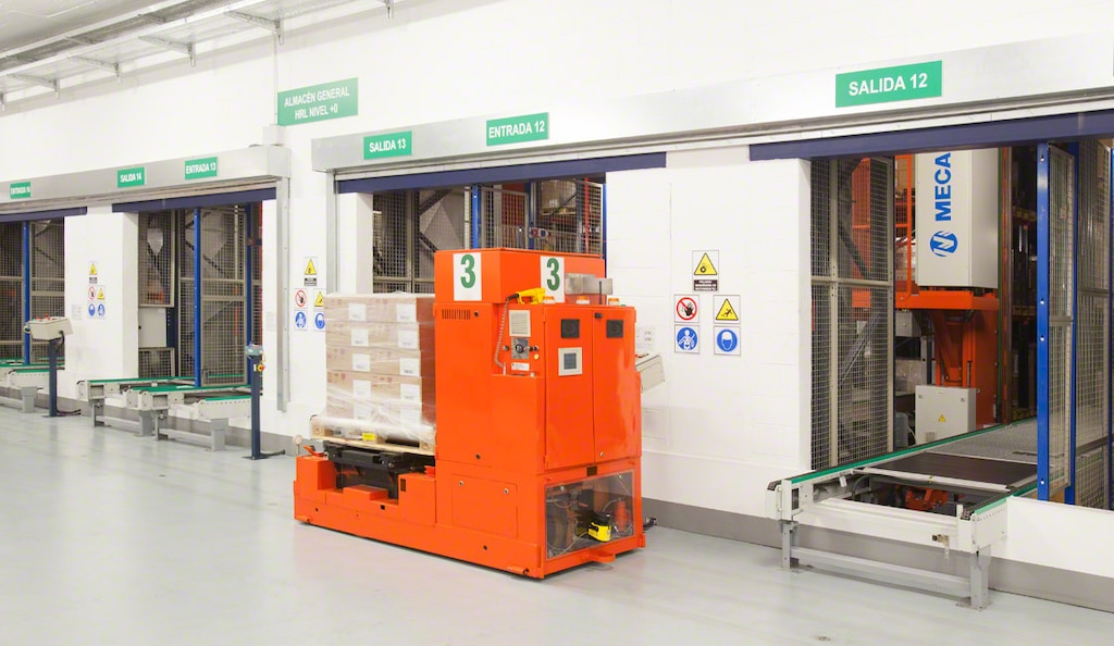 Wózki AGV w obiekcie logistycznym firmy Kern Pharma układają ładunki na przenośnikach wejściowych magazynu automatycznego