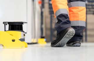 Laserowy skaner bezpieczeństwa dostosowuje tempo pracy ramienia robota przemysłowego po wykryciu w pobliżu obecności operatora Laserowy skaner bezpieczeństwa dostosowuje tempo pracy ramienia robota przemysłowego po wykryciu w pobliżu obecności operatora